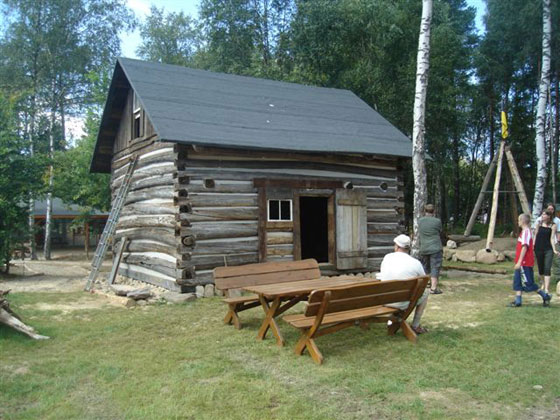 Round log building complete with chinking, roof, and windows.